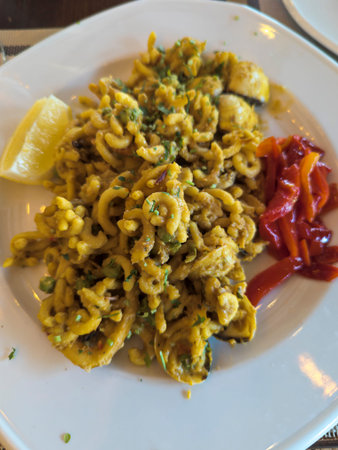 Plate of pasta with lemon and red sauce., dish