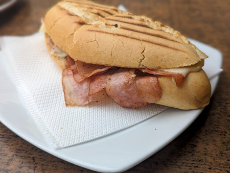 A sandwich with layers of meat on a plate., breadの写真素材