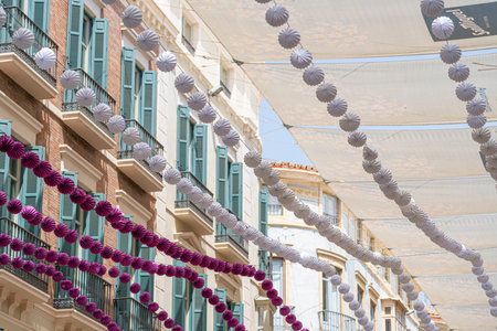 Colorful decorations hanging over a street in MÃ¡laga.. MÃ¡laga, Spain, buildingsの写真素材