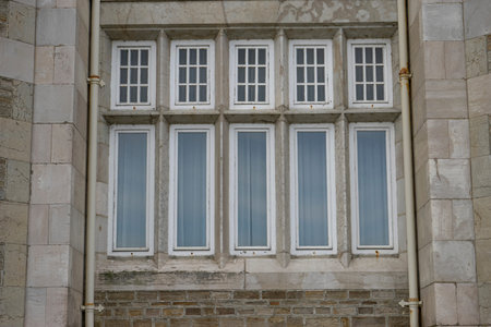 Five tall windows with white frames and stone wall.. Santander, Spain, building