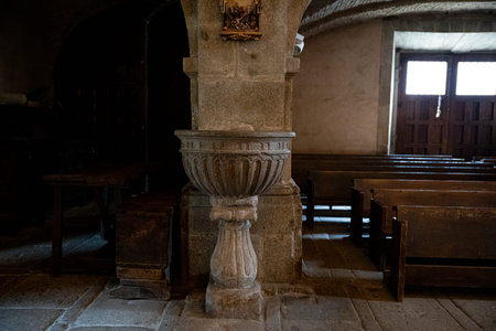 Interior of a church with wooden benches and baptismal font.. Parish Church of Our Lady of the Assumption in La Alberca, Salamanca, Spain, stoneの写真素材