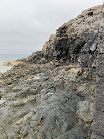 Rocky coastline with gray stones and ocean view.. Playa Blanca, Lanzarote, Spain, shore