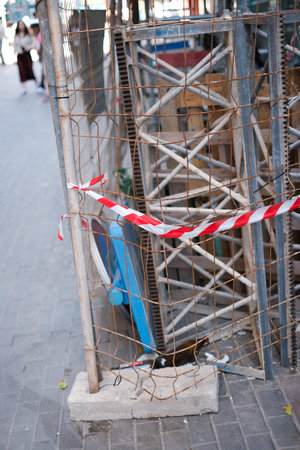 Urban construction site with safety barriers and warning tape.の写真素材