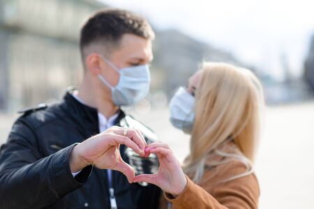 Young couple in masks on city street. Isolation, quarantine.の写真素材