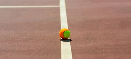 Tennis balls and rocket on court field in sunny day, sport, hobbyの写真素材