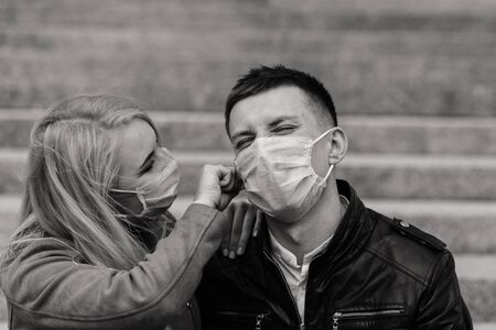 Young couple in masks on city street. Isolation, quarantine.の写真素材