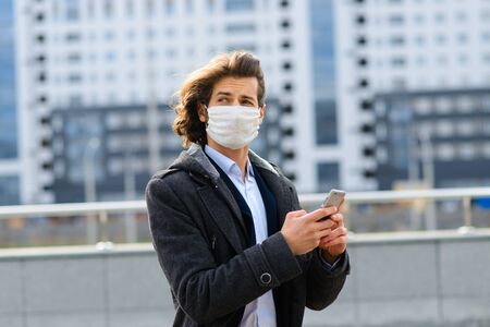 Young man in a medical mask outside, no money, crisis, poverty, hardship, isolation.の写真素材