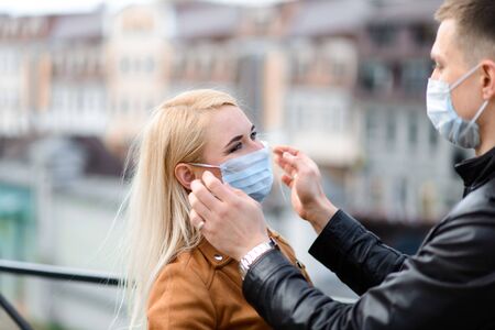 Young couple in masks on city street. Isolation, quarantine.の写真素材