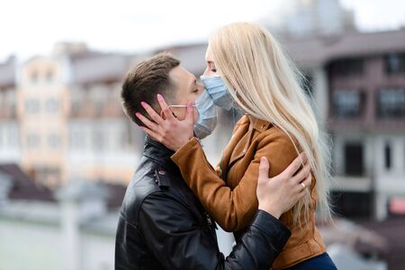 Young couple in masks on city street. Isolation, quarantine.の写真素材