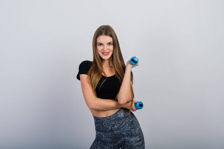 Young girl with dumbbells on a white background, fitness, sportの写真素材
