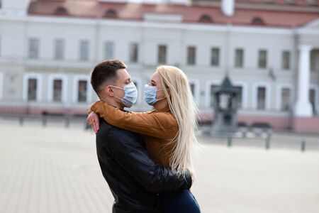 Young couple in masks on city street. Isolation, quarantine.の写真素材