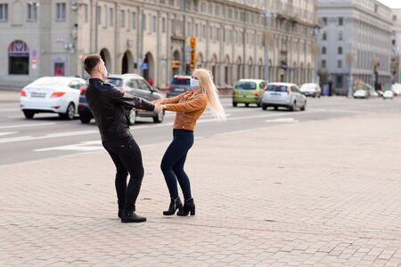 Young couple in masks on city street. Isolation, quarantine.の写真素材