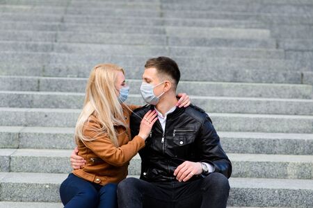 Young couple in masks on city street. Isolation, quarantine.の写真素材