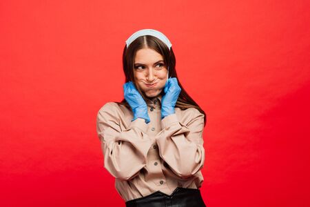 Emotional female in medical mask and gloves. Pandemic coronavirus epidemic covid-19 quarantine isolated redの写真素材