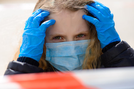 Portrait of sad Caucasian girl in face mask at the city and in the park outdoor. Social distance...