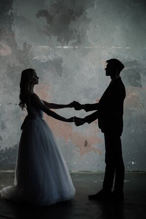 Art fashion studio photo of wedding couple silhouette groom and bride on colors background.の写真素材
