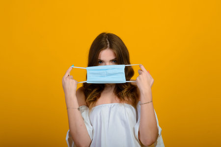 Dark-haired young woman with a smile and big suprised eyes posing on yellow background. Word ideas...