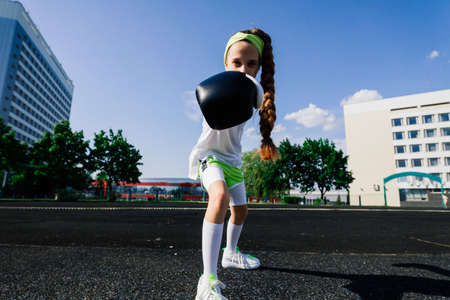 Female child boxer in gloves, feminism concept. Back to school, physical training.の写真素材