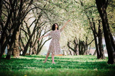 Woman ballerina in blooming garden. pink. Portrait of dancing female outdoor.の写真素材