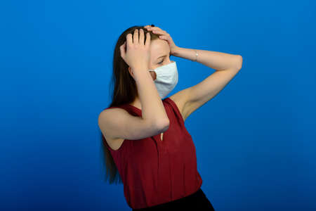 Girl in protective medical mask and blue gloves on blue background. close-up portrait of a woman in a transparent mask. way to protect against coronavirus. Covid-2019, Pandemic 2020の写真素材