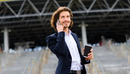 Portrait of an handsome businessman with phone, coffee cup in the city streets