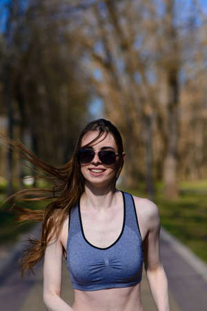 Beautiful athletic girl in sport clothes and glasses on the playground. Healthy lifestyle.の写真素材