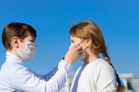 Children in a city park in a medical mask. Walking on the street during the quarantine period of the coronavirus pandemic in the world. Precautions childrenの写真素材