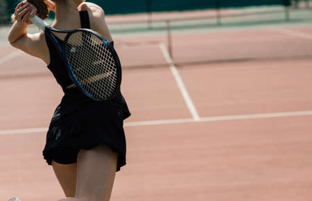 Sexy girl tennis player in white dress and heels holding tennis racket on the court. Young woman is playing tennis, sportの写真素材