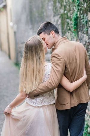 Salo, Italy - 02.02.2020. Romantic young couple sitting on the river dock and walking on the lake bank.のeditorial素材