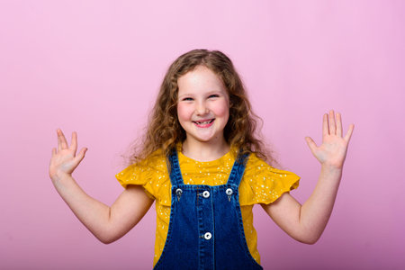 Happy carefree child emotions. Energetic joyful adorable little girl laughing at joke on pink...