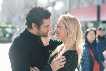 Barcelona, Spain - 02.02.2020. The male holds his wife's hand and tenderly looking at her and walking on the streets city.のeditorial素材