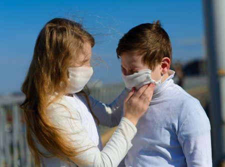 Children in a city park in a medical mask. Walking on the street during the quarantine period of the...