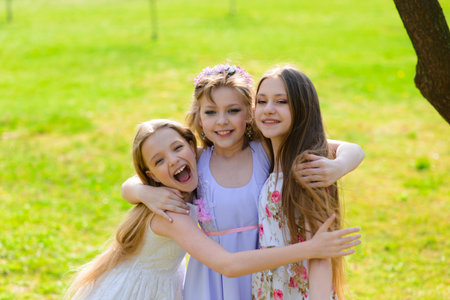 Three beautiful girls in retro dresses for a walk in a flowered garden. The idea and concept of a...