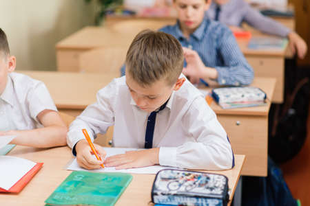 Minsk, Belarus - 09.01.2020. Elementary schoolchildren writing in books in classroomのeditorial素材