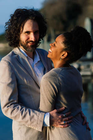 Bologne, Italy - 02.04.2020. Young adult interracial couple on a beach, Caucasian man and African American female in casual clothes enjoying summer day on a sea shoreのeditorial素材