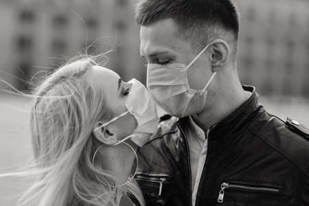 Young couple in masks on city street. Isolation, quarantine.の写真素材