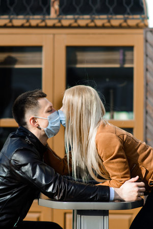 Young couple in masks on city street. Isolation, quarantine.