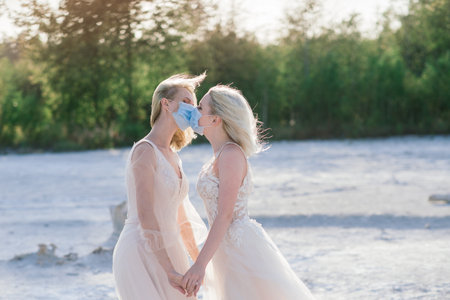 Lesbian couple wedding on white sand, wear masks to prevent epidemic COVID-19の写真素材