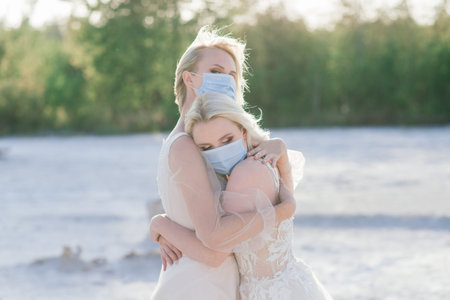Lesbian couple wedding on white sand, wear masks to prevent epidemic COVID-19の写真素材