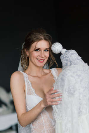 Beautiful sexy bride in white lingerie lying on the bed in her bedroomの写真素材