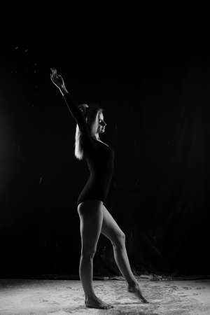 A gorgeous blond model with perfect figure posing in a black bodysuit.の写真素材