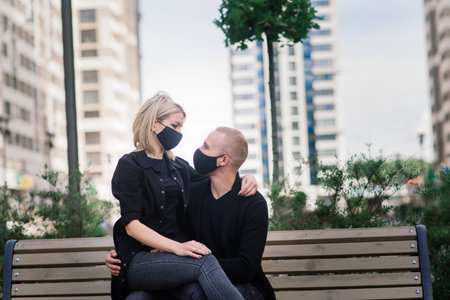 Couple wearing fashionable protective masks, walking in empty street of the city during quarantine.の写真素材