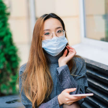 Young asian woman with surgical mask face protection. She commutes between home and workplace in cityの写真素材