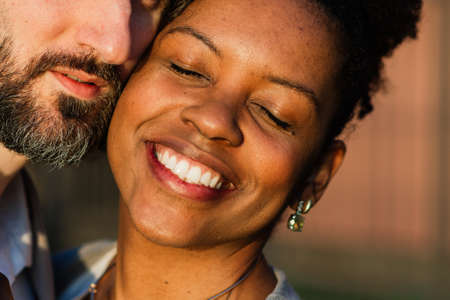 Milan, Italy - 02.04.2020. Young adult interracial couple on a beach, Caucasian man and African American female in casual clothes enjoying summer day on a sea shoreのeditorial素材