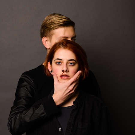 Desparate female with aggressive man in studio, domestic violence conceptionの写真素材