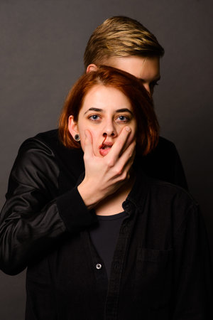 Desparate female with aggressive man in studio, domestic violence conception