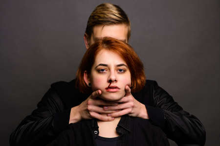 Desparate female with aggressive man in studio, domestic violence conceptionの写真素材