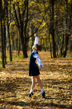 Ballerina dancing in nature park among autumn leaves.の写真素材