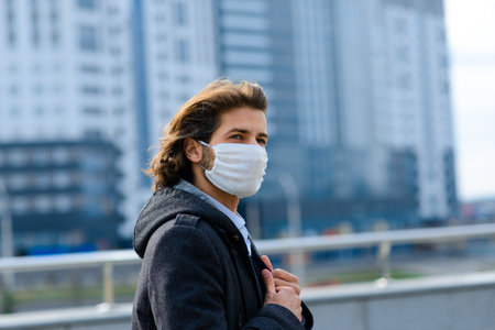 Young man in a medical mask outside, no money, crisis, poverty, hardship, isolation.の写真素材