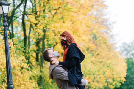 Young couple wearing masks together in forest, parkの写真素材
